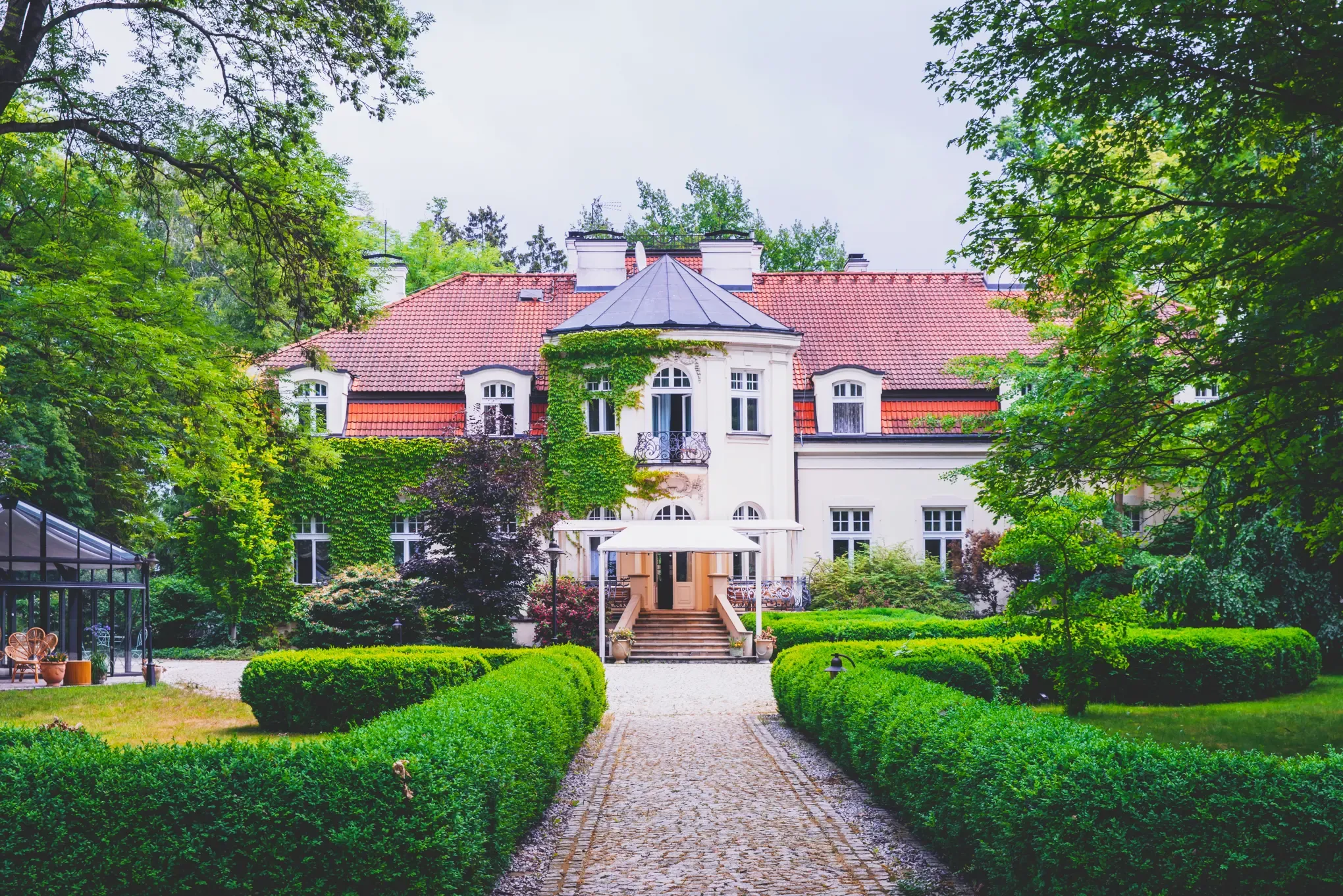 The garden approach to Pałac Zdunowo, lined with boxwood hedges